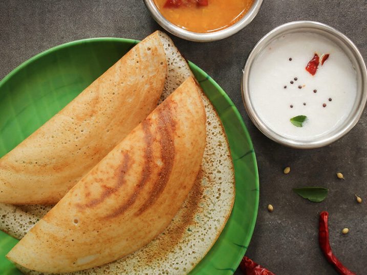 Golden ghee roast dosa served with sambar and chutneys